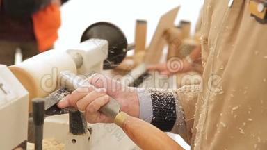 在<strong>工作室</strong>里，<strong>木工</strong>师傅用木圆柱形的木条来引导木匠转动的细节
